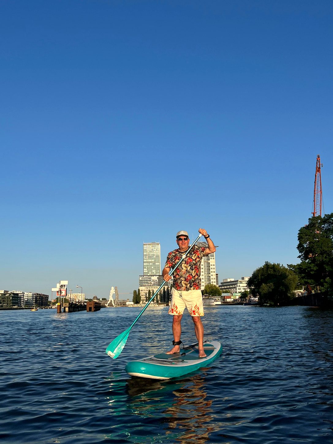 Stefan paddelt auf der Spree, im Hintergrund die Berliner Skyline