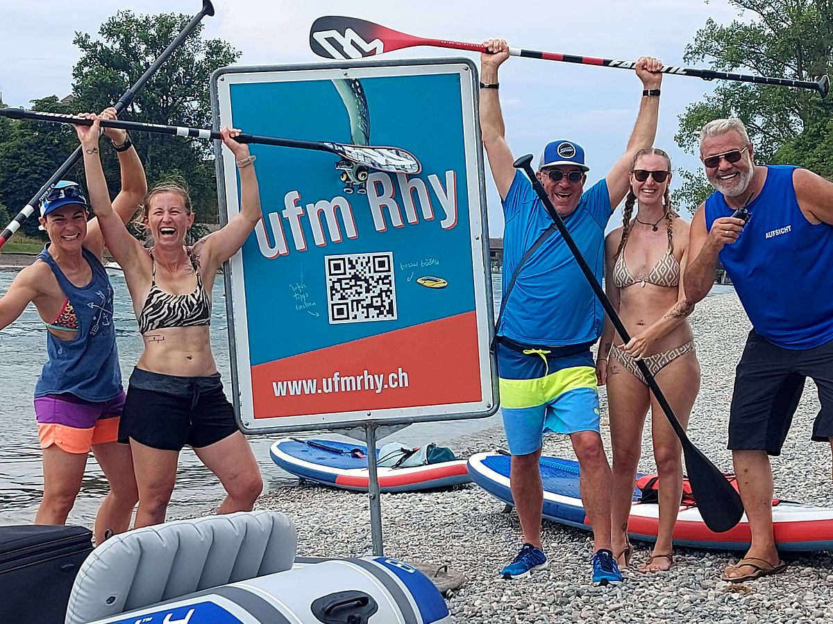 Gruppe mit Paddeln am Ufer nach der Tour
